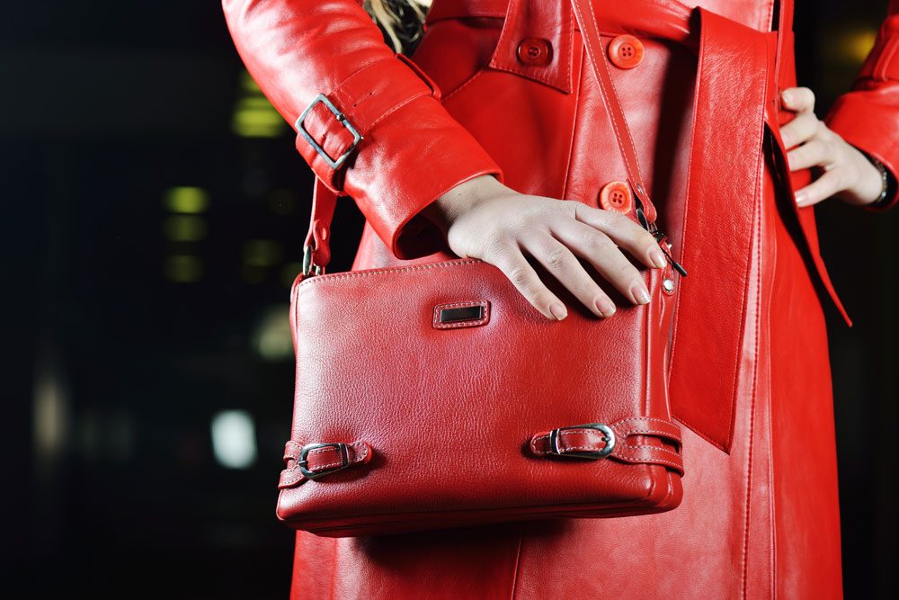 Frau in roter Lederjacke mit Handtasche.