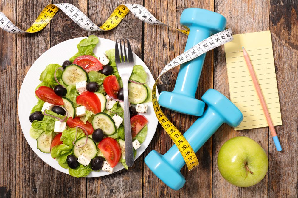 Salat und Hanteln für Fitness und Gesundheit.