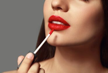 Frau schminkt sich Lippen.