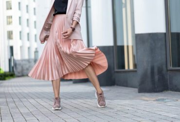 Frau trägt Turnschuhe und Rock.