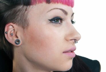 Frau mit Piercings an Ohr und Nase.