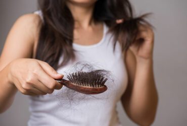 Frau mit Haarbürste und losen Haaren.