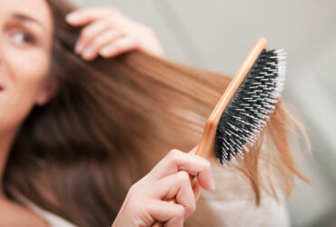 Frau bürstet sich die Haare.