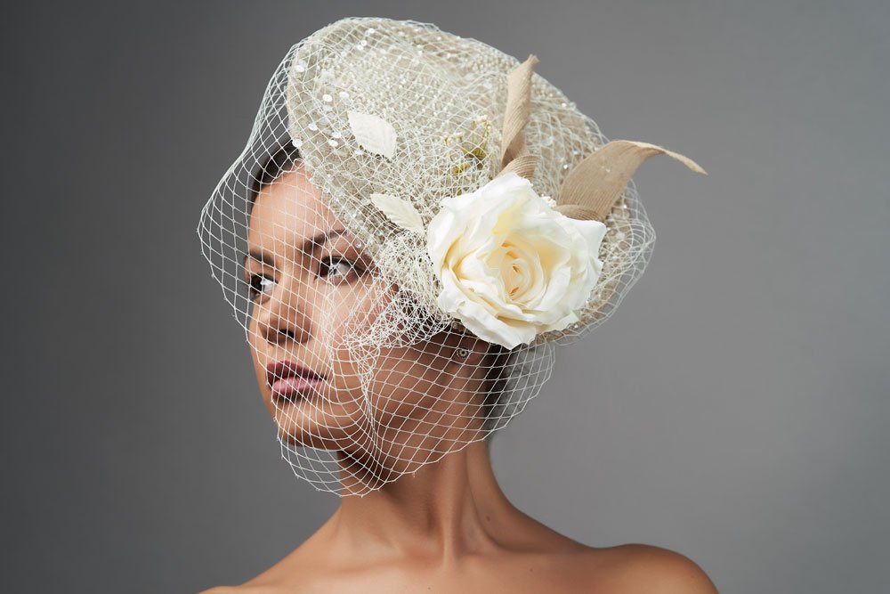 Der Fascinator sollte unbedingt mit einem Haarreif verbunden sein Braut trägt einen Fascinator