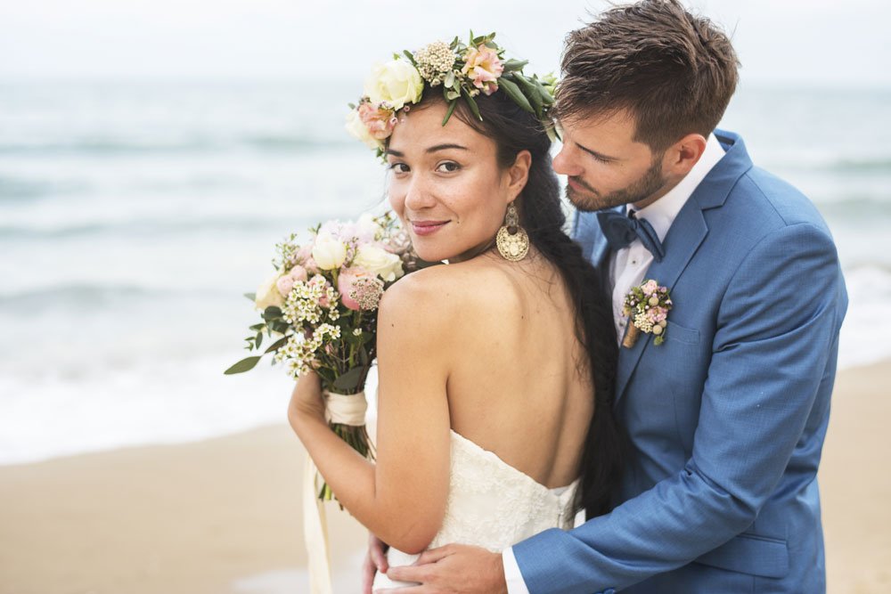 Brautpaar mit Blumenstrauß am Strand