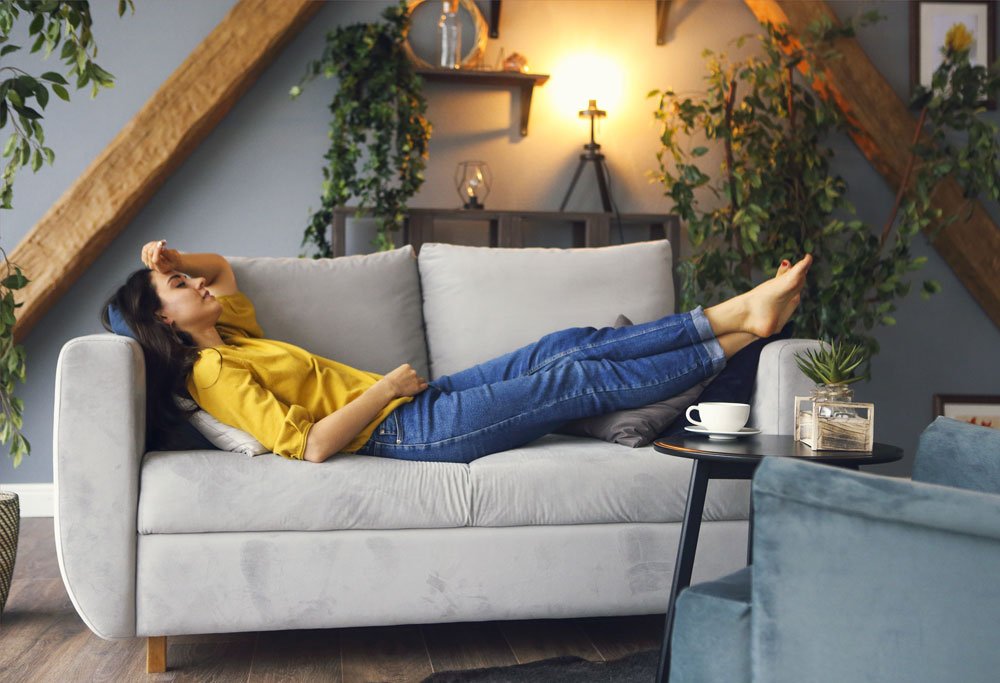Stress ist Gift für den Stoffwechsel Frau ruht sich auf dem Sofa aus