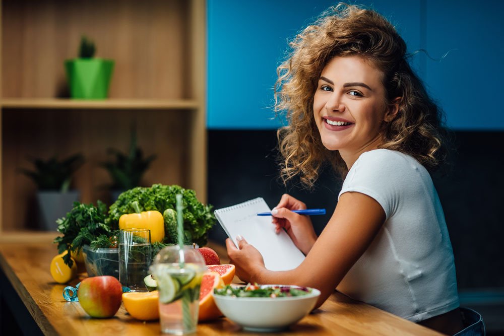 Führe am besten ein Ernährungstagebuch Frau führt Ernährungstagebuch