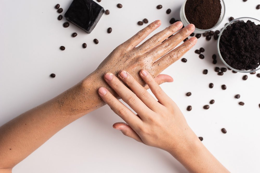 Frau peelt ihre Hände mit Kaffeesatz Handpeeling aus Kaffeesatz