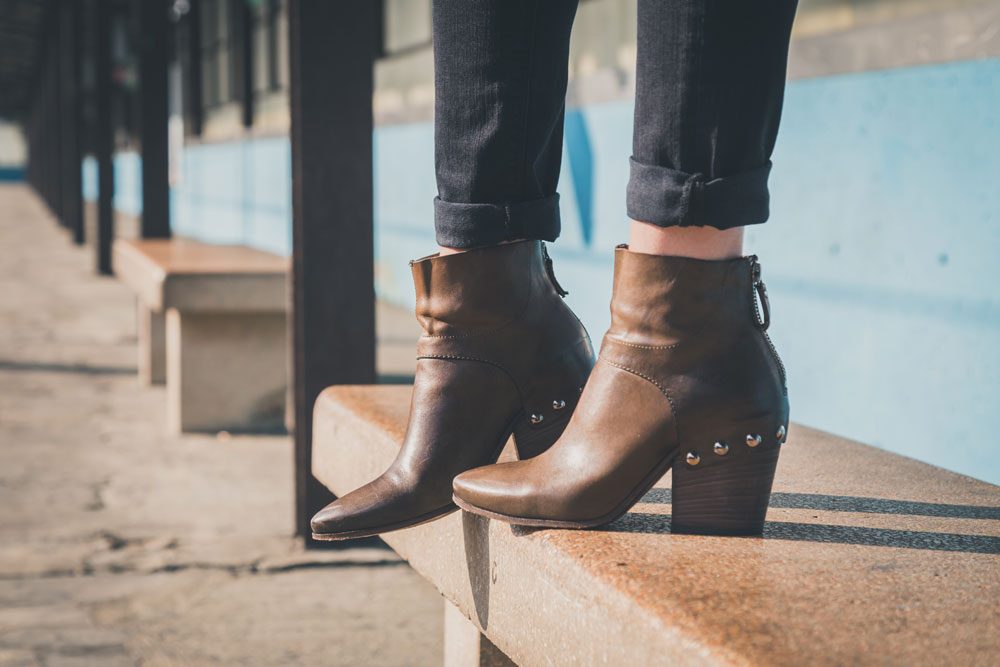 Ankle Boots Frau mit bruanen Ankle Boots aus Leder.