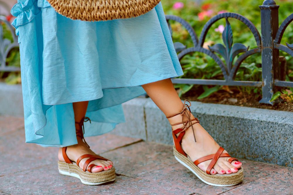 Frau trägt Riemchenschuhe zum Maxikleid.